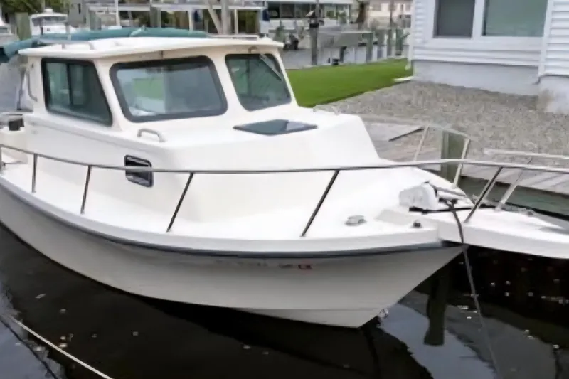 Slide: The Image of 2001 Parker 2520 Modified Vee Sport Cabin boat docked near a waterfront home. - 5