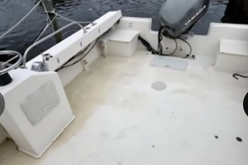 Slide: The Image of 2001 Parker 2520 Modified Vee Sport Cabin boat deck with motor and seating. - 6