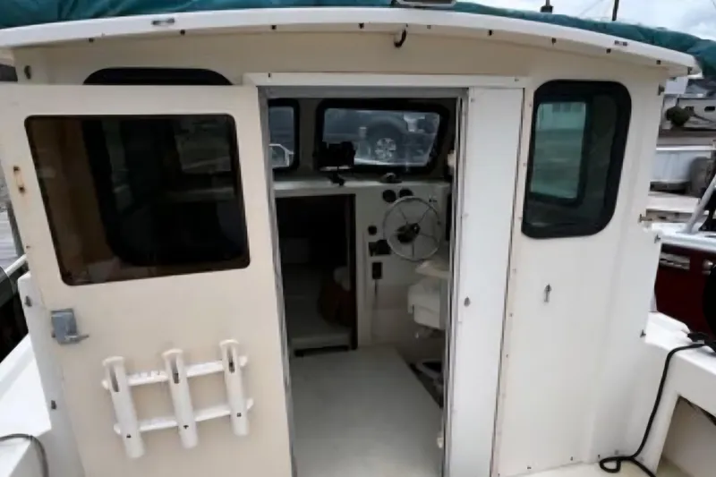 Slide: The Image of 2001 Parker 2520 Modified Vee Sport Cabin boat interior with steering wheel and windows. - 9