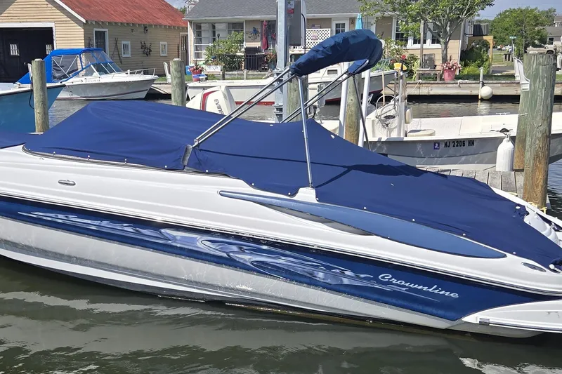 The Image of 2007 Crownline 220 LS boat docked with blue cover in a marina. - 0