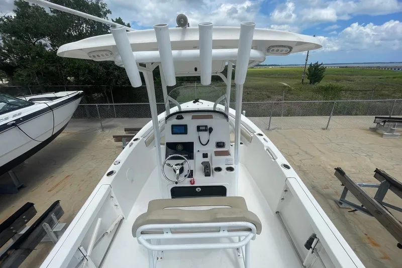Slide: The Image of 2016 Sea Pro 219 Center Console boat with steering wheel and control panel, docked outdoors. - 2