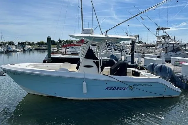 Slide: The Image of 2018 Cobia 237 Center Console boat docked in a marina. - 1
