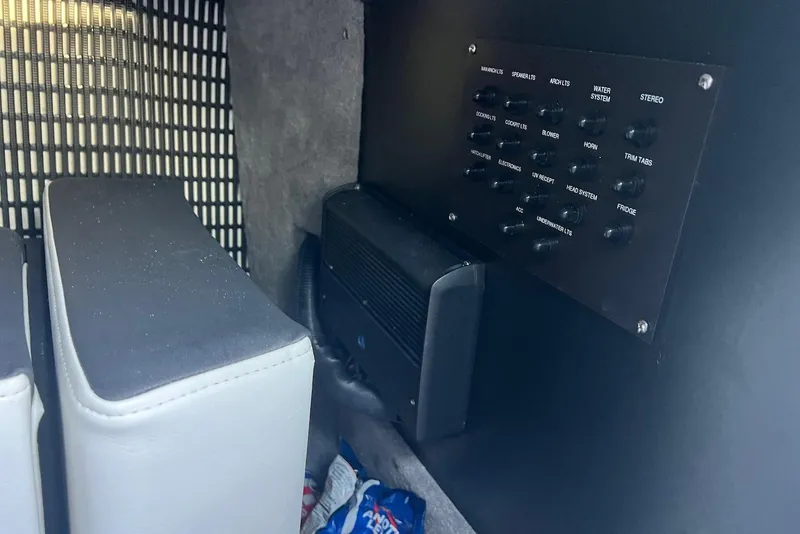 Slide: The Image of Control panel inside 2025 Monterey 255 Super Sport boat, featuring various switches and cushioned seating. - 21