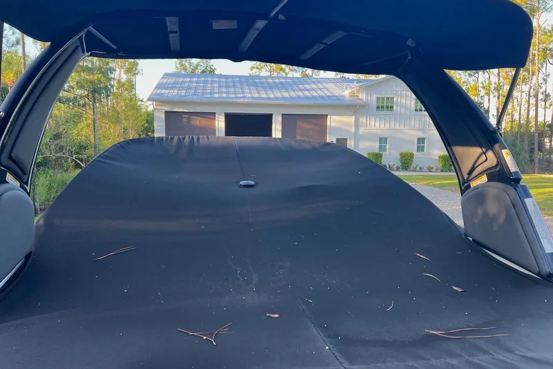 Slide: The Image of 2025 Monterey 255 Super Sport boat with cover, parked near a modern house. - 24