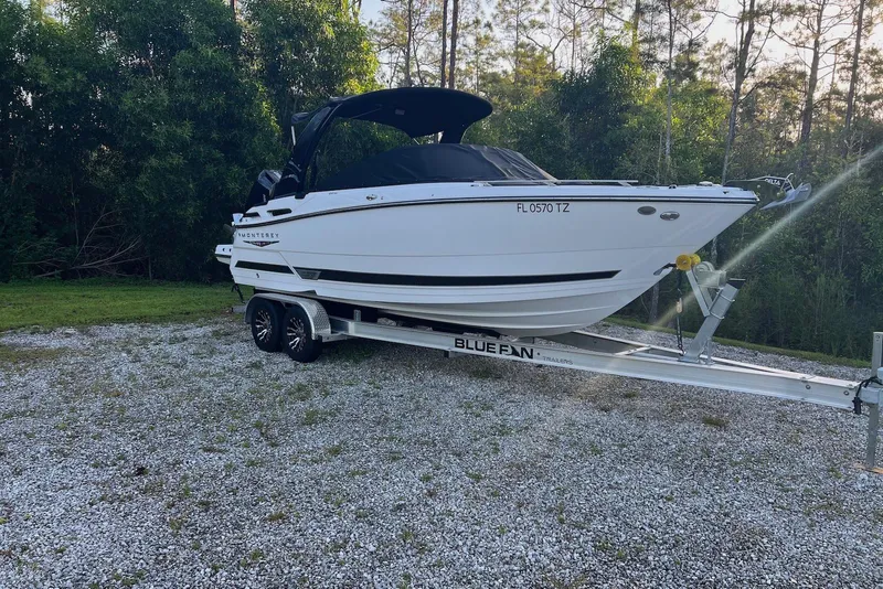 Slide: The Image of 2025 Monterey 255 Super Sport boat on trailer, parked outdoors with trees in background. - 4