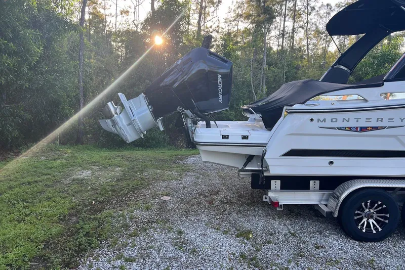 Slide: The Image of 2025 Monterey 255 Super Sport boat on trailer, surrounded by trees, with sunlight filtering through. - 5