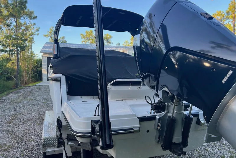 Slide: The Image of 2025 Monterey 255 Super Sport boat with outboard motor, parked on a gravel driveway. - 8