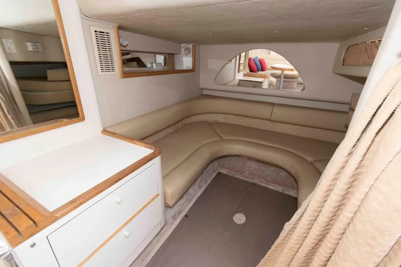 Slide: The Image of Interior of 1995 Sea Ray 370 Sundancer with beige seating, table, and TV. - 12