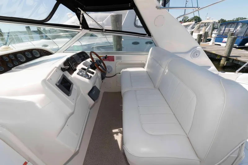 Slide: The Image of 1995 Sea Ray 370 Sundancer boat with white seating and table at a marina dock. - 5