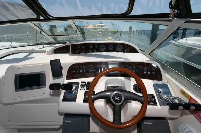 Slide: The Image of 1995 Sea Ray 370 Sundancer cockpit with white seating and control panel. - 7