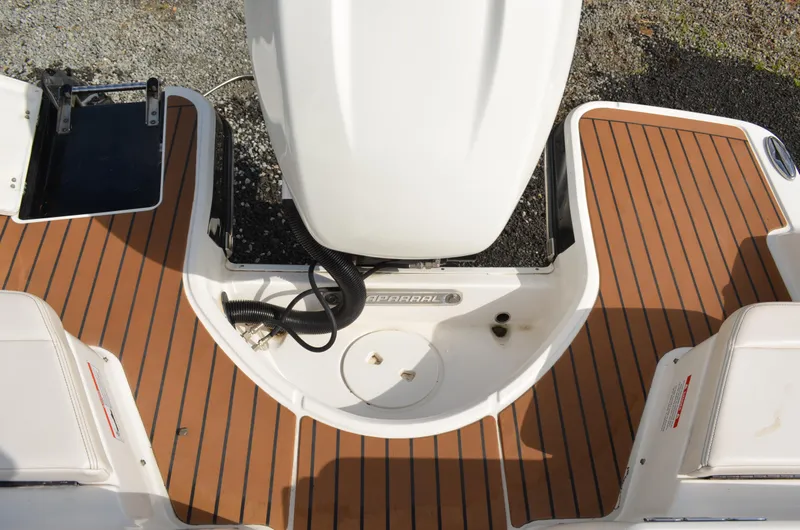 Slide: The Image of 2018 Chaparral 250 Suncoast boat deck with wood finish and engine compartment. - 15