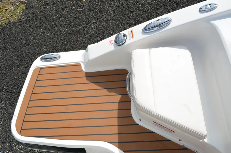 Slide: The Image of 2018 Chaparral 250 Suncoast boat deck with cushioned seating and wood-style flooring. - 19