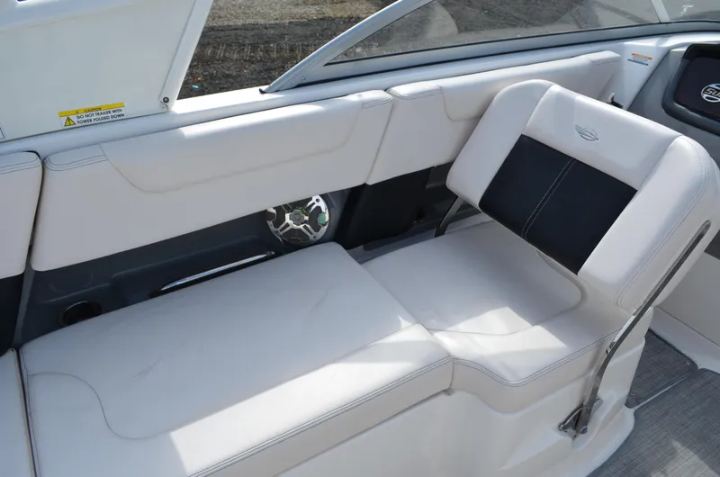 Slide: The Image of 2018 Chaparral 250 Suncoast boat interior with white seating and speaker detail. - 24