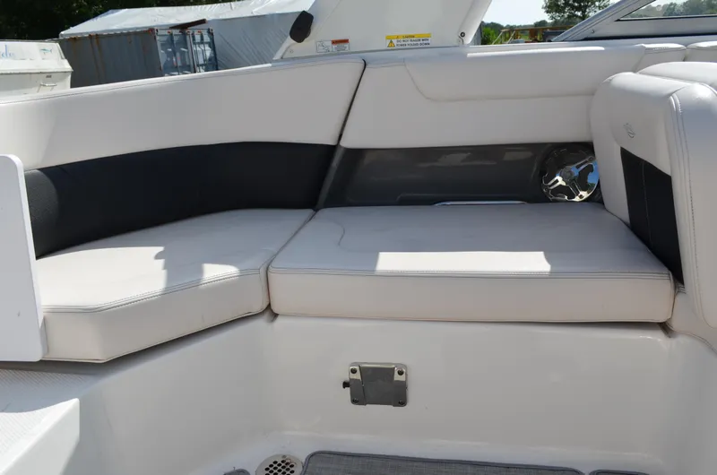 Slide: The Image of 2018 Chaparral 250 Suncoast boat interior seating with white and black upholstery. - 28