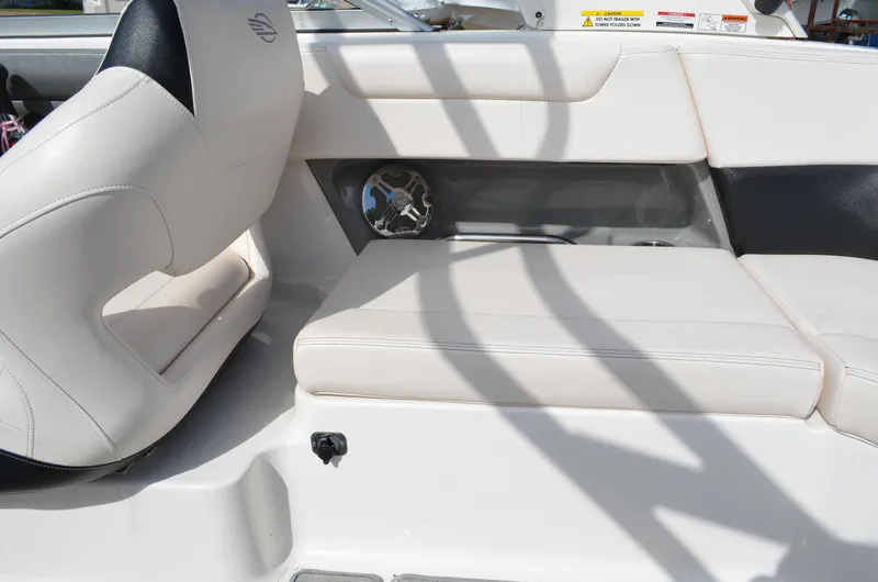 Slide: The Image of 2018 Chaparral 250 Suncoast boat interior with white seating and speaker detail. - 29