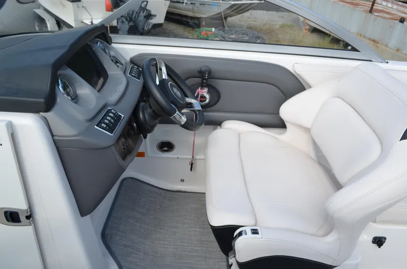 Slide: The Image of 2018 Chaparral 250 Suncoast boat interior with steering wheel and white seating. - 31