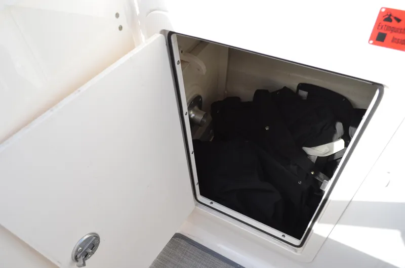 Slide: The Image of Storage compartment on 2018 Chaparral 250 Suncoast boat, open with items inside. - 37