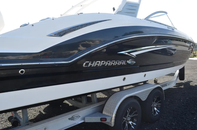 Slide: The Image of 2018 Chaparral 250 Suncoast boat on trailer, sleek black and white design. - 6