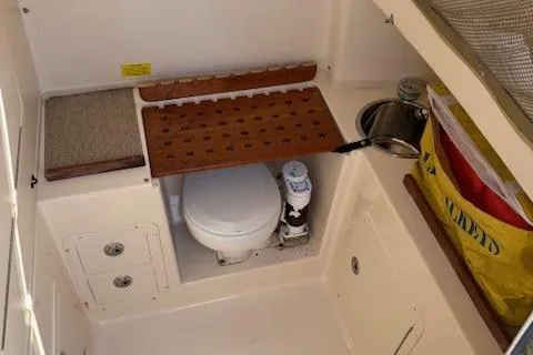 Slide: The Image of 2011 Grady-White Canyon 306 boat interior with compact marine toilet and storage. - 11