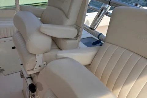 Slide: The Image of 2011 Grady-White Canyon 306 boat seats with white upholstery and armrests. - 6