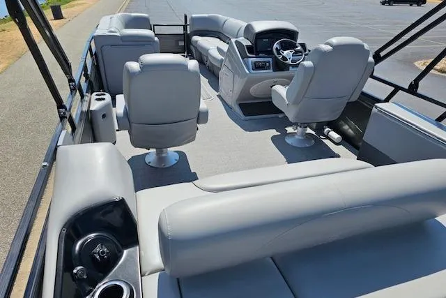 Slide: The Image of 2024 Regency 250 DL3 pontoon boat interior with plush seating and modern dashboard. - 3