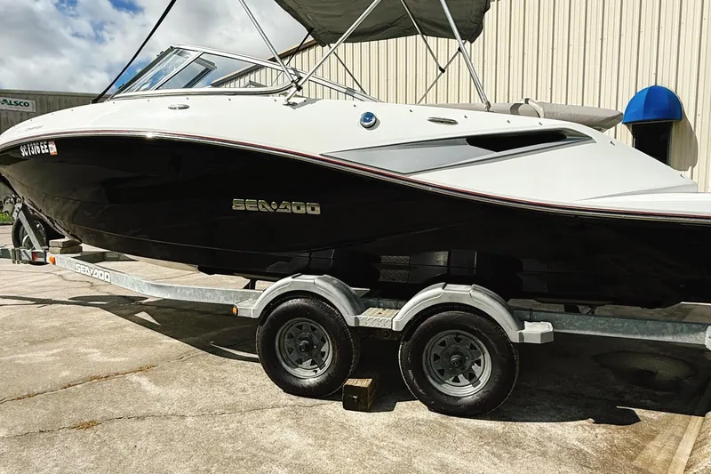 Slide: The Image of 2010 Seadoo 210 Challenger SE boat on trailer, parked outdoors. - 2