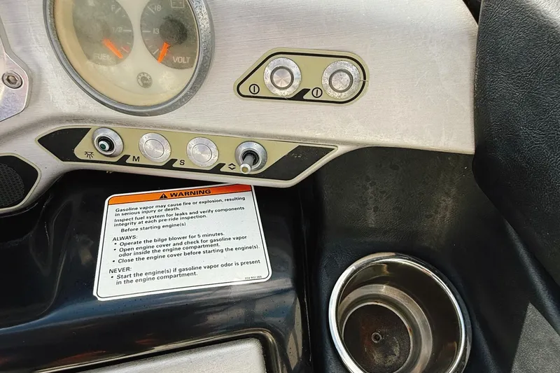 Slide: The Image of Dashboard controls of a 2010 Seadoo 210 Challenger SE with warning label and cup holder. - 24