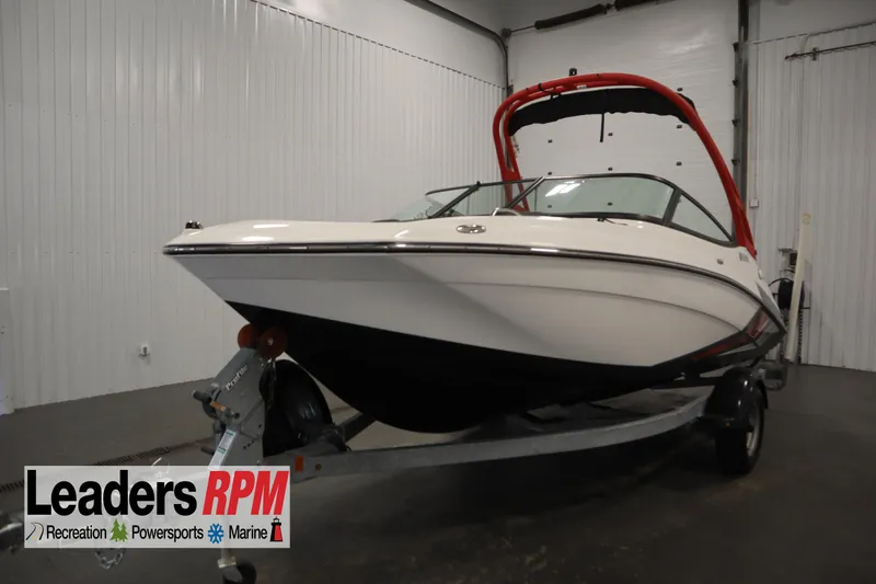 The Image of 2018 Yamaha Boats AR195 in showroom, featuring sleek design and red wakeboard tower. - 1