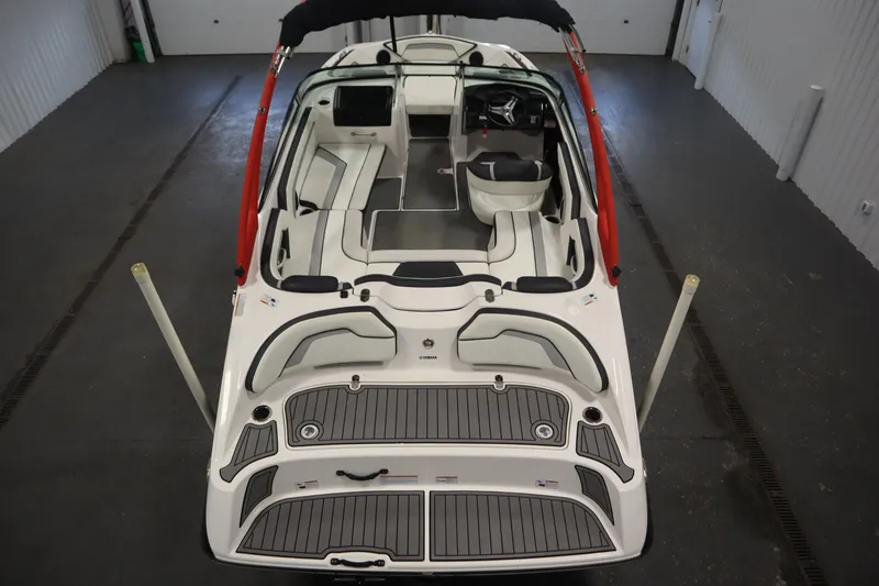 Slide: The Image of 2018 Yamaha Boats AR195 interior view, showcasing seating and helm in a garage setting. - 10