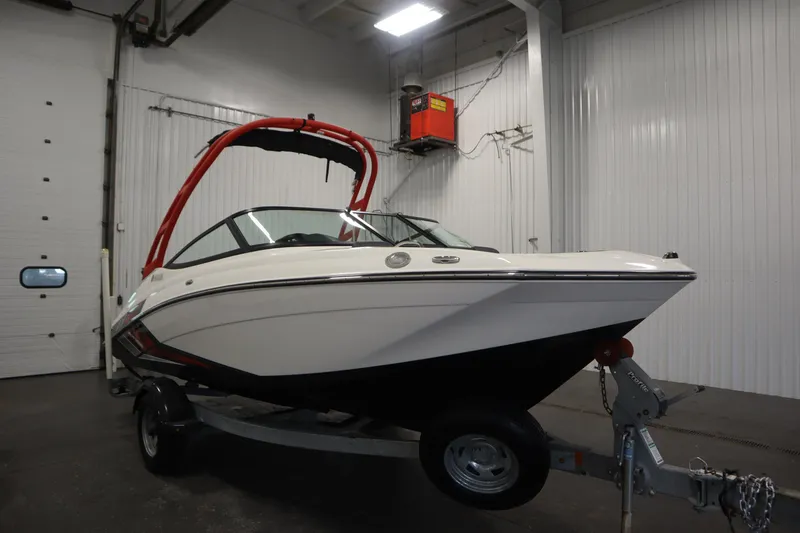 Slide: The Image of 2018 Yamaha AR195 boat with red wakeboard tower in indoor storage. - 3