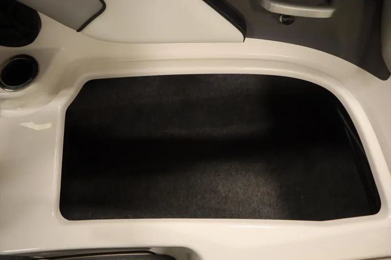 Slide: The Image of 2018 Yamaha AR195 boat interior storage compartment with black carpet lining. - 42