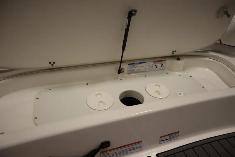 Slide: The Image of 2018 Yamaha Boats AR195 storage compartment with open lid and safety instructions. - 45