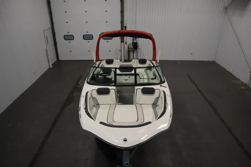 Slide: The Image of 2018 Yamaha AR195 boat in indoor storage, featuring sleek design and red wakeboard tower. - 9