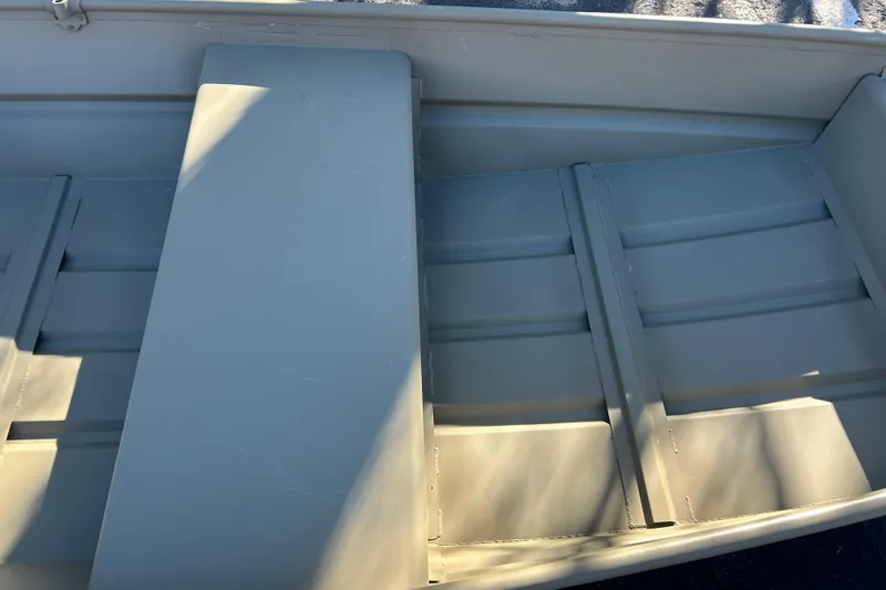 Slide: The Image of 2026 Tracker Grizzly 12 Jon boat interior with bench seats and aluminum finish. - 3