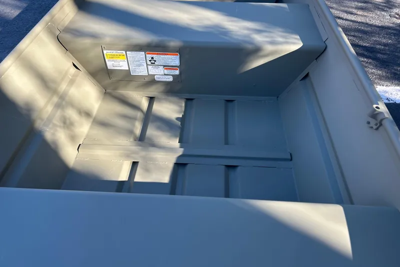 Slide: The Image of 2026 Tracker Grizzly 12 Jon boat interior with safety labels visible. - 4