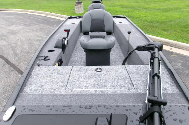 Slide: The Image of 2025 Tracker Panfish 17 boat interior with seating and fishing equipment on a wet surface. - 2
