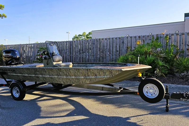 Slide: The Image of 2026 Tracker Grizzly 1860 CC boat on trailer, parked outdoors. - 2