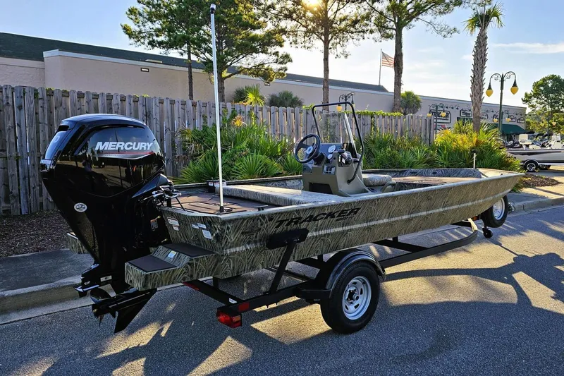 Slide: The Image of 2026 Tracker Grizzly 1860 CC boat with Mercury engine on trailer, parked outdoors. - 3
