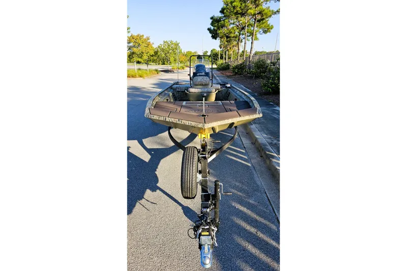 Slide: The Image of 2026 Tracker Grizzly 1860 CC boat on trailer, parked on a sunny street. - 6