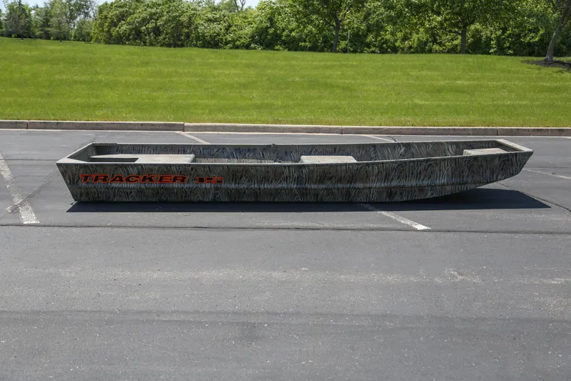 The Image of 2026 Tracker Grizzly 15 Jon boat parked on asphalt, surrounded by greenery. - 0
