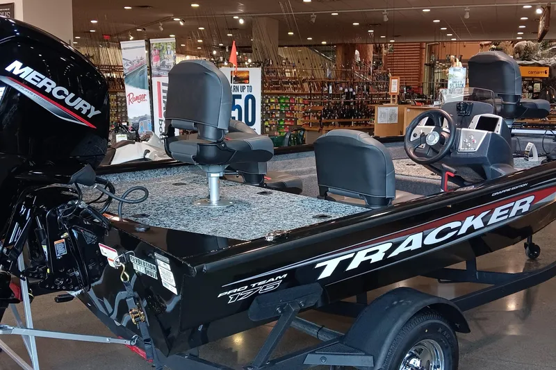 Slide: The Image of 2026 Tracker Pro Team 175 Crappie Edition boat displayed indoors with Mercury engine. - 2