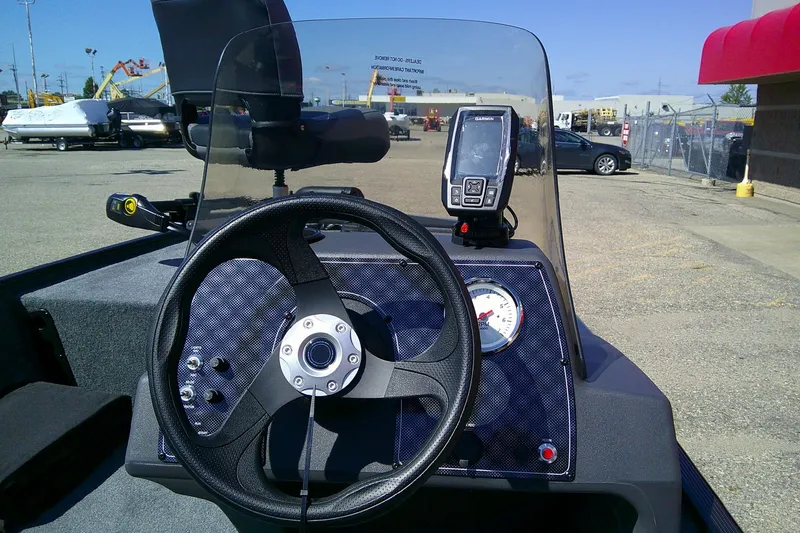 Slide: The Image of 2026 Tracker Bass Tracker Classic XL boat dashboard with steering wheel and GPS device. - 4