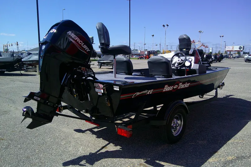 Slide: The Image of 2026 Tracker Bass Tracker Classic XL boat with Mercury engine in parking lot. - 63