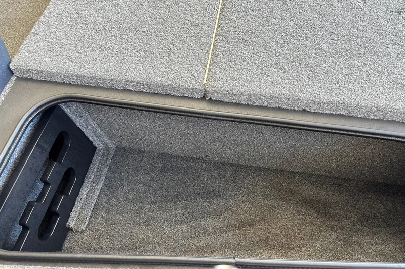 Slide: The Image of Storage compartment of 2025 Tracker Pro Team 175 Crappie Edition boat, featuring carpeted interior. - 29