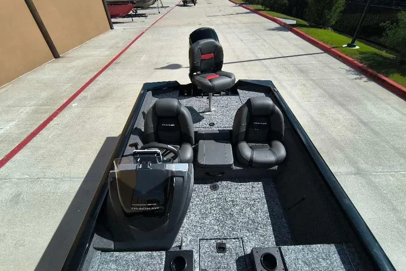 Slide: The Image of 2026 Tracker Pro Team 190 boat with seating and console, parked on concrete. - 6
