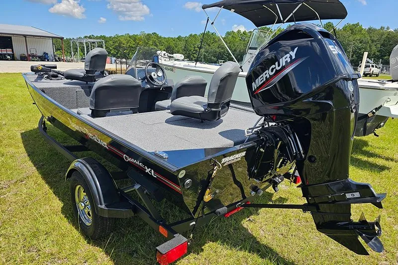 Slide: The Image of 2026 Tracker Bass Tracker Classic XL boat with Mercury engine on grassy field. - 3