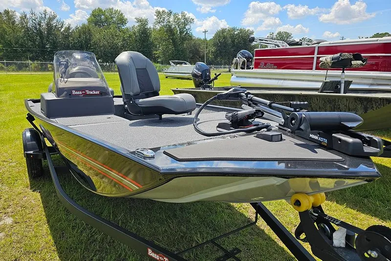 Slide: The Image of 2026 Tracker Bass Tracker Classic XL boat on grassy field under blue sky. - 5