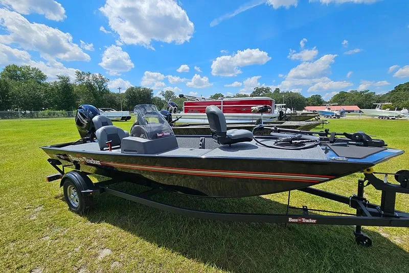 Slide: The Image of 2026 Tracker Bass Tracker Classic XL boat on grassy field under blue sky. - 6