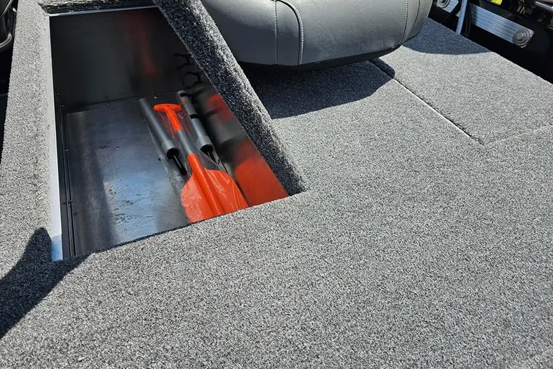 Slide: The Image of 2026 Tracker Bass Tracker Classic XL boat storage compartment with orange paddles. - 9