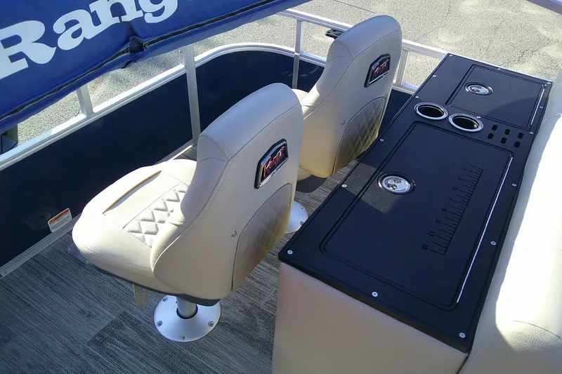 Slide: The Image of 2024 Ranger Reata 220FC boat interior with beige seats and black console. - 7